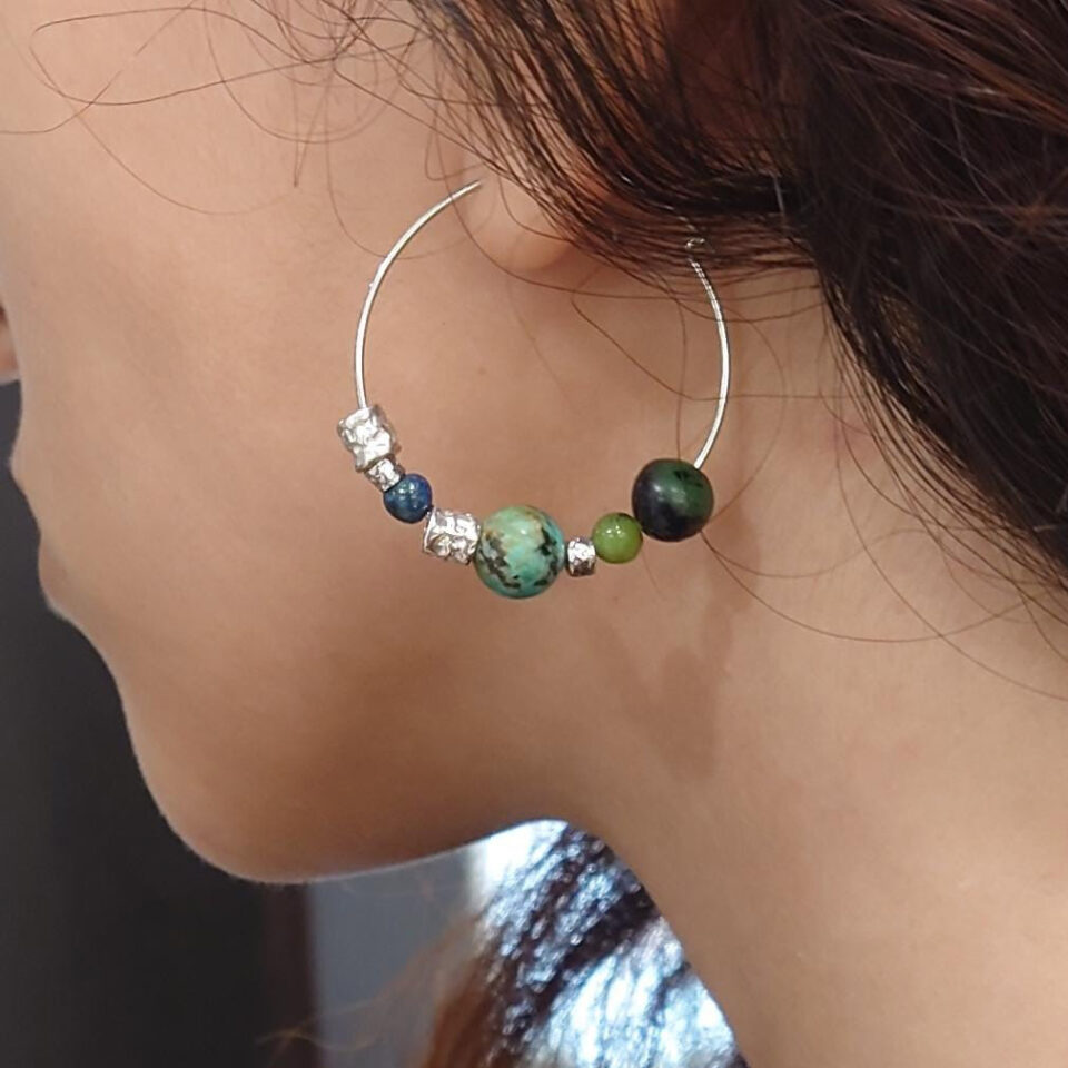 orecchini a cerchio con pietre verdi indossati